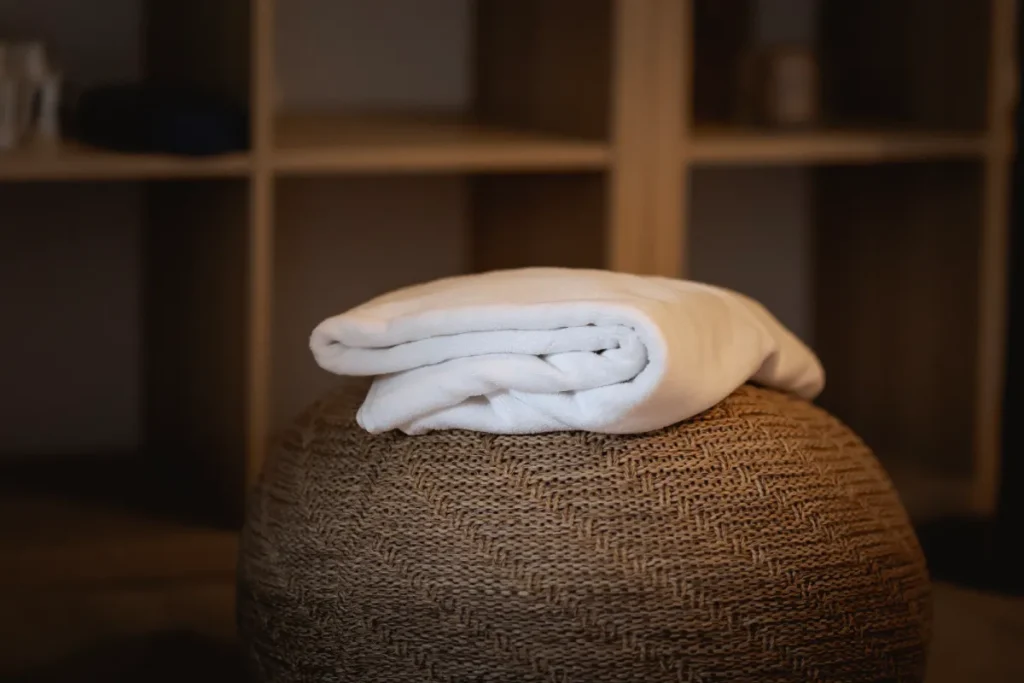 Detailní záběr na pečlivě složený, měkký ručník na stylovém odkladači v Mystery Wellness na Morávce, připravený pro hosty.